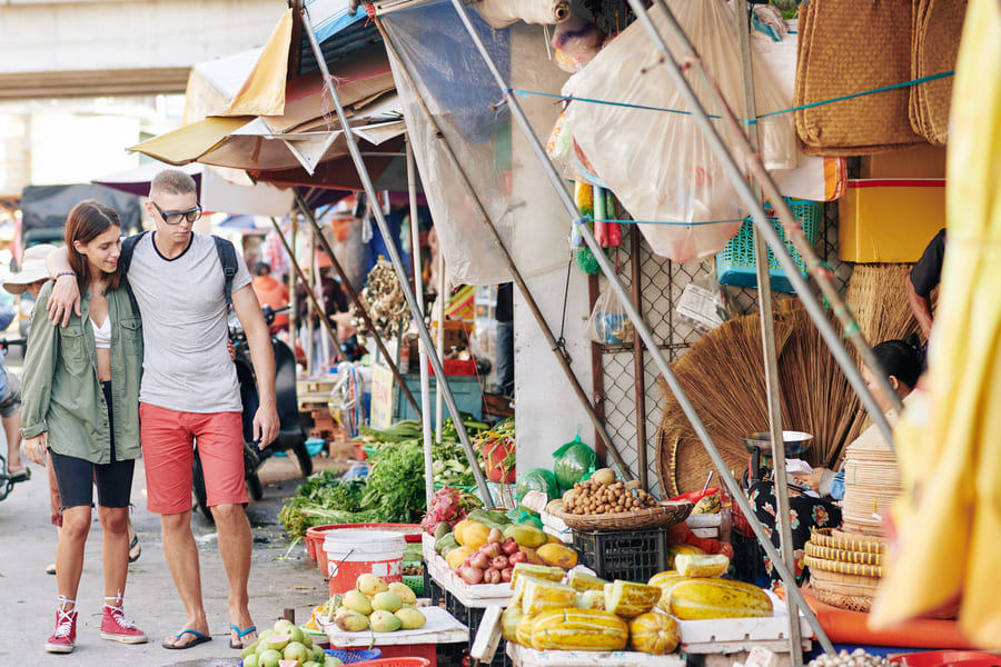 Una pareja de turistas caminando en un bullicioso mercado al aire libre en China
